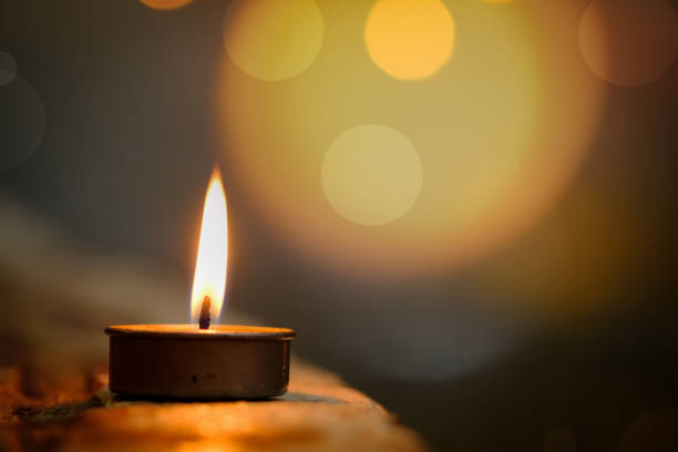 istock Prayer and hope concept.Candle flame light at night with abstract circular bokeh background 944025536