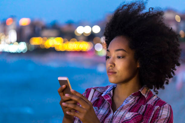 istock Woman using smart phone on street at night 944025926