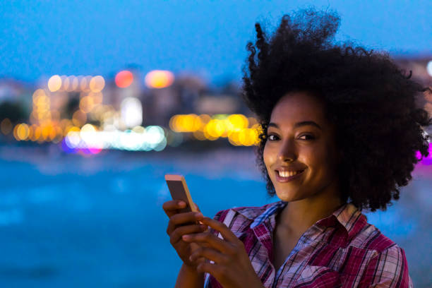 istock Woman using smart phone on street at night 944025928