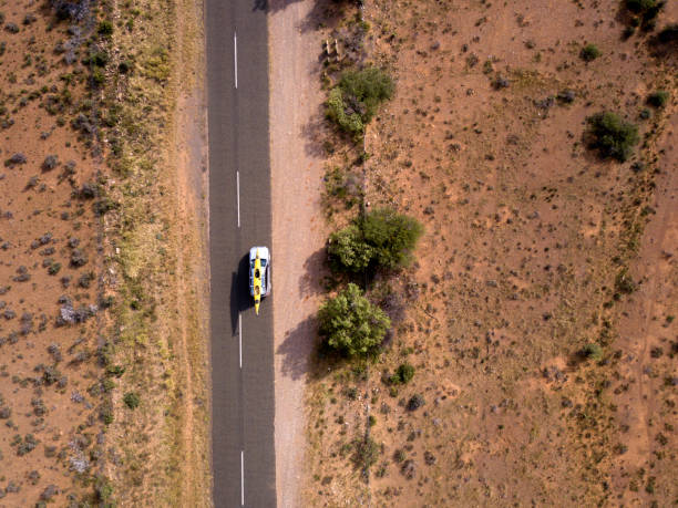 istock Aerial of car travelling down a long empty road 944027076