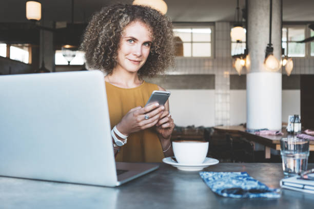 istock woman in city cafe, using mobile phone 944031486