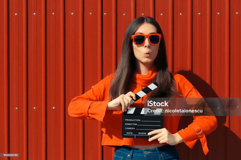 Beautiful Woman with Cinema Clapper on Red Background Cool model girl with film slate at casting audition Movie Stock Photo