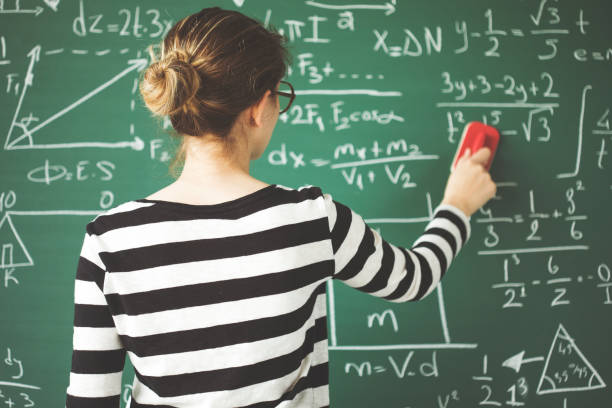 istock Young student cleaning green chalkboard with duster  in classroom 944038668