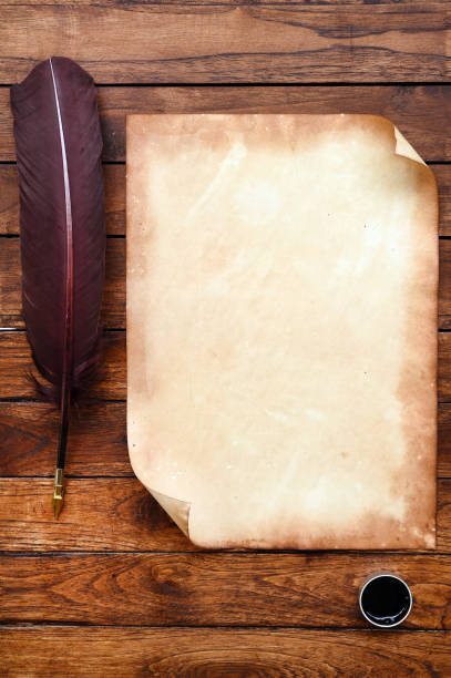 istock old paper on brown wood texture with feather and ink 944043418