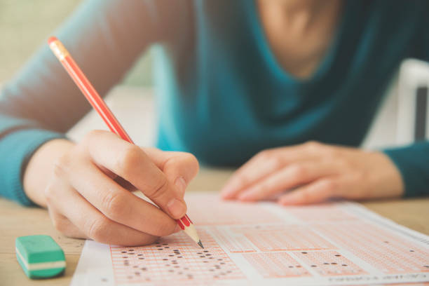 Female student holding pencil and examination paper stock photo