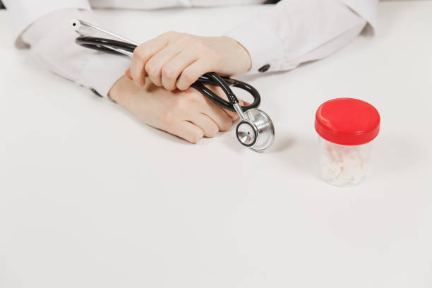 Doctor at white desk with bottle white pills in office in hospital. Woman holds in hands stethoscope in consulting room. Medicine concept. Copy space advertisement. With text place. Advertising area. Doctor at white desk with bottle white pills in office in hospital. Woman holds in hands stethoscope in consulting room. Medicine concept. Copy space advertisement. With text place. Advertising area niñas stock pictures, royalty-free photos & images