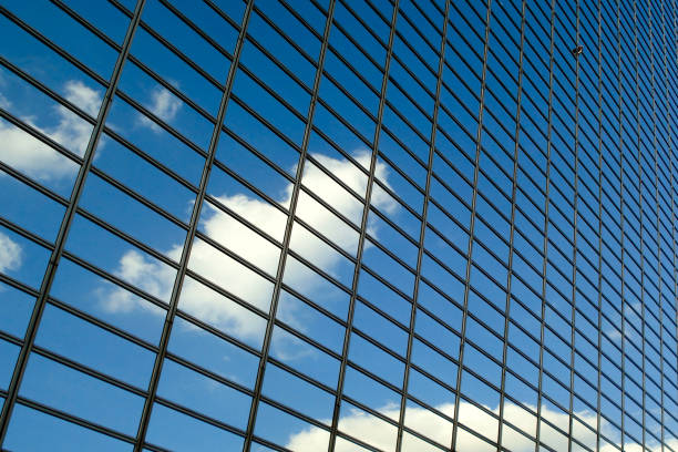 istock Blue sky with clouds reflections on a modern glass business building 944046482