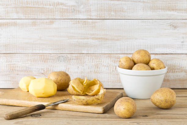 raw and peeled potatoes - potato skin imagens e fotografias de stock