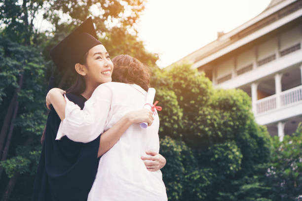 Young female graduate hugging her mother at graduation ceremony, Success,Goal. Education concept. stock photo