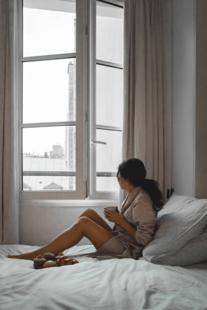 Woman having breakfast in bed in Paris