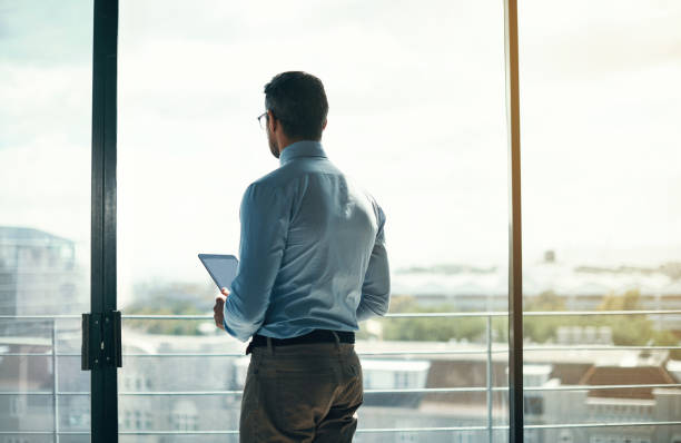 私の成功は、街全体に知られる - businessman looking through window ストックフォトと画像