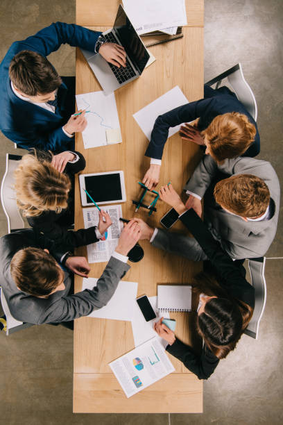 istock overhead view of business partners doing construction with pencils at table in office 944064292