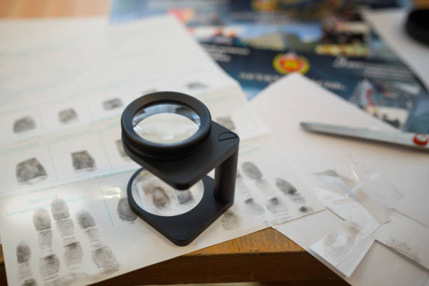 istock Criminology expert through a magnifying glass looking at a fingerprint 944069210