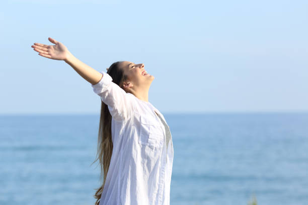 istock Satisfied woman breathing on the beach 944069458