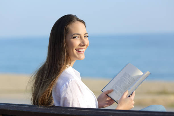istock Woman holding an open book looking at camera 944069534