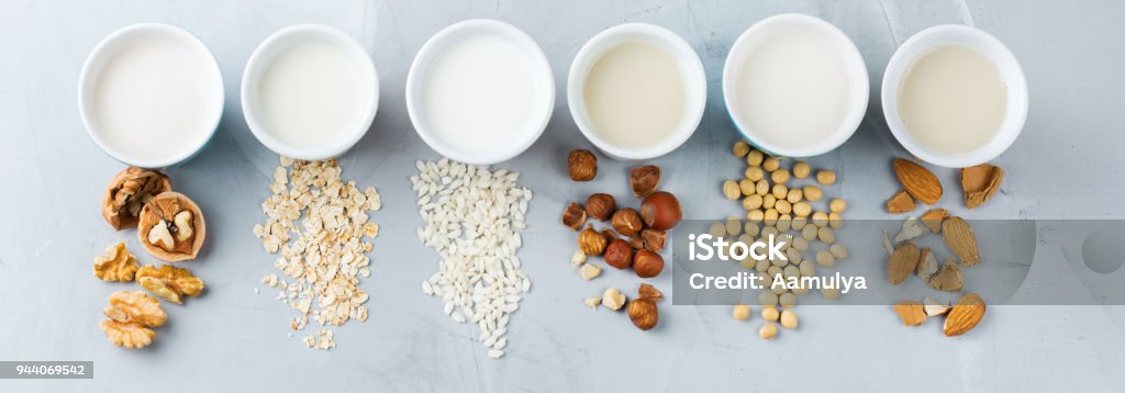 Assortment of organic vegan non diary milk Food and drink, health care, diet and nutrition concept. Assortment of organic vegan non diary milk from nuts, oatmeal, rice, soy in glasses on a kitchen table. Top view flat lay background Milk Stock Photo