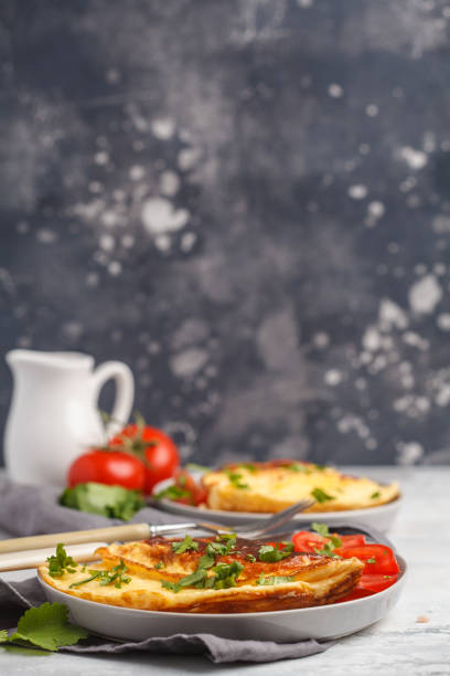 istock Delicious bright egg omelet with cheese and vegetables. Breakfast food concept, dark background 944076646