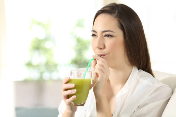 istock Girl drinking vegetable juice sipping a straw 944080920