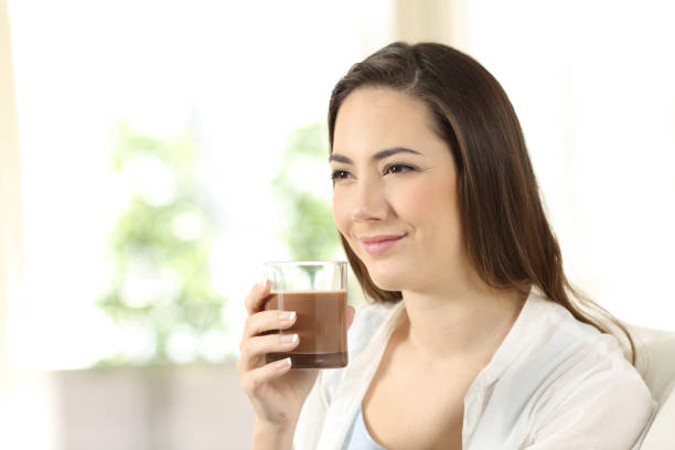 istock Woman holding a cocoa shake looking away 944081176