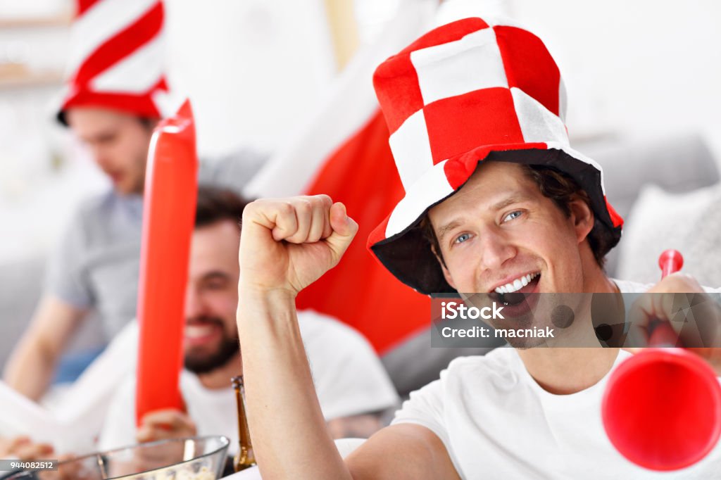 Happy male friends cheering and watching sports on tv Picture of happy male friends cheering and watching sports on tv Poland Stock Photo