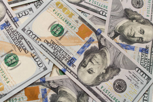 istock A lot of hundred dollar bills scattered on the table 944085472