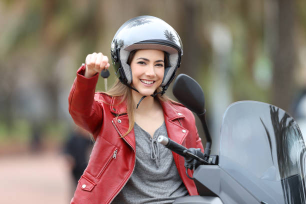 istock Biker showing motorbike keys on her scooter 944085474