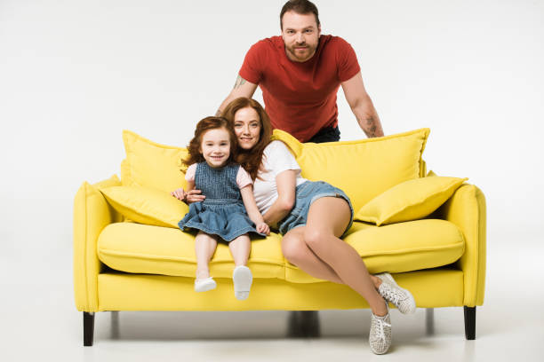 istock Happy family with sofa isolated on white 944086128