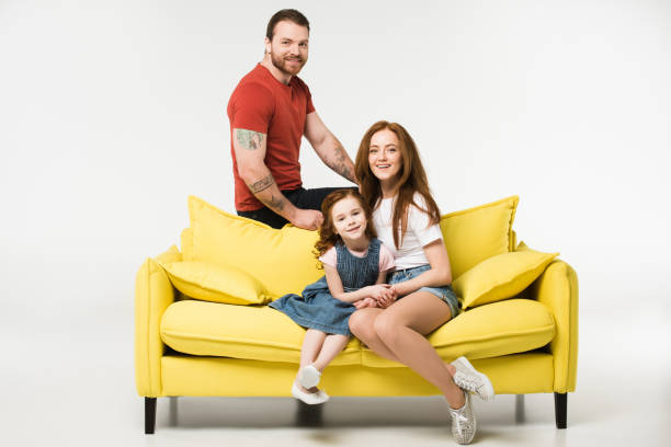 istock Happy family sitting on couch isolated on white 944088606