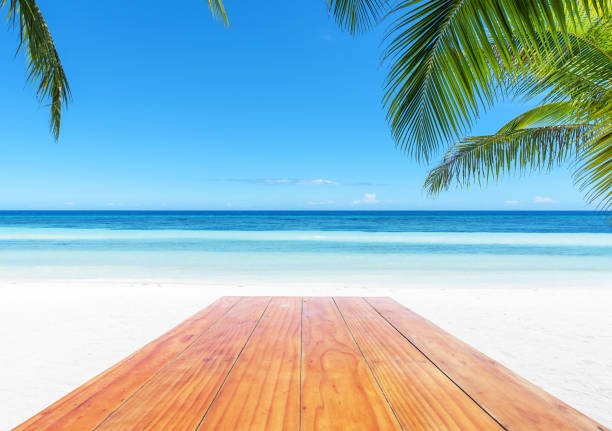 istock Empty wooden table beside tropical paradise beach 944093810