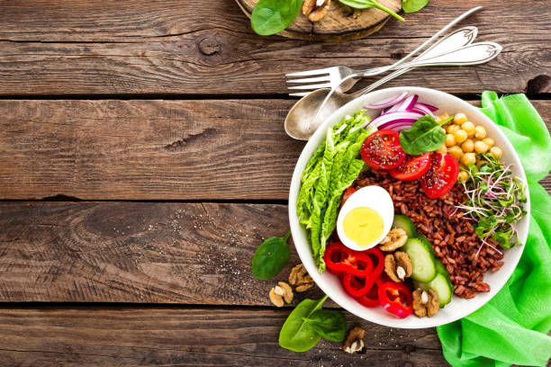 istock Buddha bowl dish with boiled egg, chickpea, fresh tomato, sweet pepper, cucumber, savoy cabbage, red onion, green sprouts, spinach leaves, walnuts, chia and rice 944102106