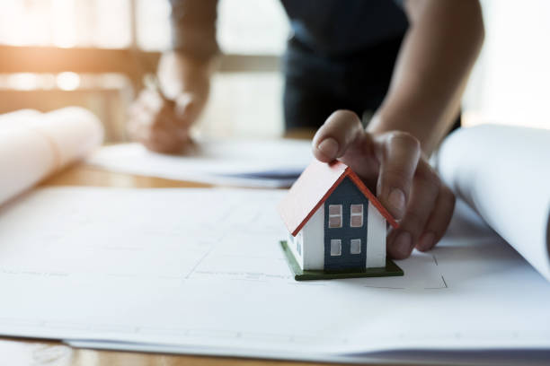 istock Close up hands holding house model, Engineer working on blueprint Construction concept. Engineering tools. Vintage tone. 944102474