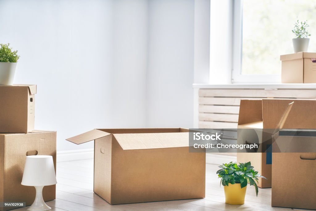 Cardboard boxes in room Cardboard boxes in empty new apartment. Box - Container Stock Photo