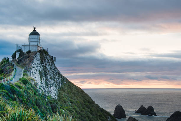 istock Lighthouse sunrise at Nugget Point,Tokata Wall 15 944103496