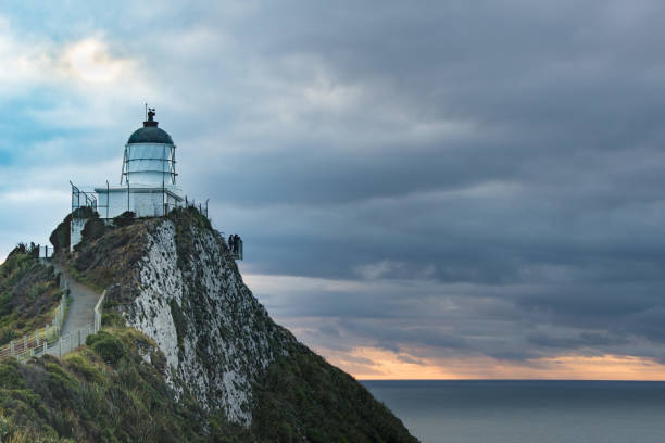 istock Lighthouse sunrise at Nugget Point,Tokata Wall 16 944103534