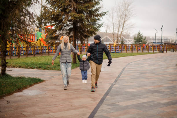 istock Young mother and father walking with a little son 944107008