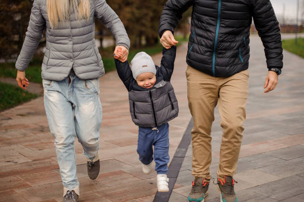 istock Cute little boy holding parents hands and jumping 944111520