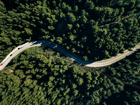 Aerial view from drone of curve road on the mountain with green forest in Greece