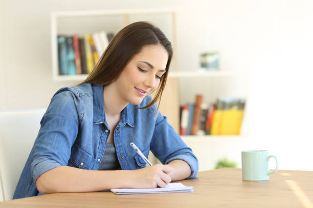 istock Girl writing in a notebook at home 944130226
