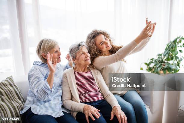 A Teenage Girl Mother And Grandmother With Smartphone At Home Stock Photo - Download Image Now