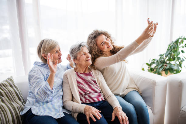 nastoletnia dziewczyna, matka i babcia ze smartfonem w domu. - 3 generation zdjęcia i obrazy z banku zdjęć