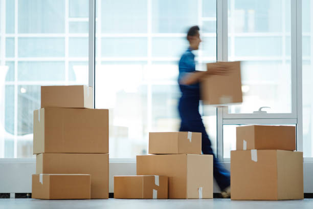 Packages with supplies Blurred motion of contemporary worker with packed box walking to new office while delivering it to client post structure photos stock pictures, royalty-free photos & images