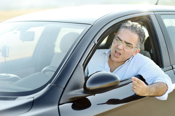 istock Road rage concept - irritated man screams and gestures while driving the car 944149022