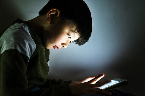 Little boy play cell phone at night