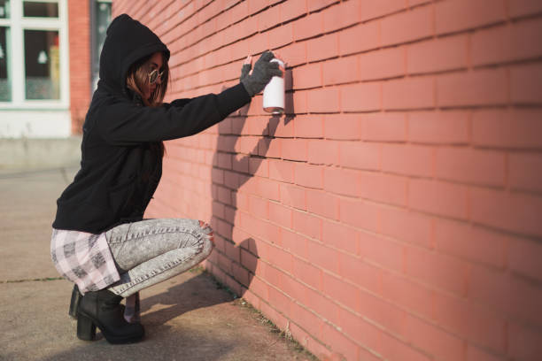istock Young hipster writing graffiti on the brick wall with a spray can 944179108