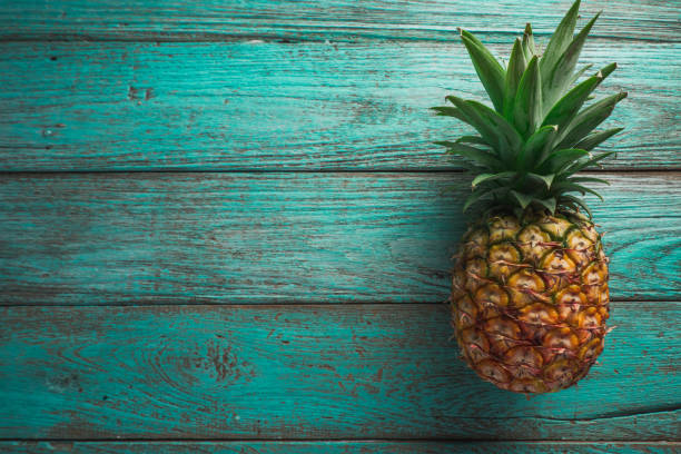 istock pineapple on the wood texture background 944179842