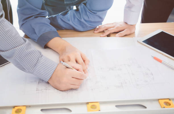 istock Business Colleagues Discussing Over Blueprint 944184406