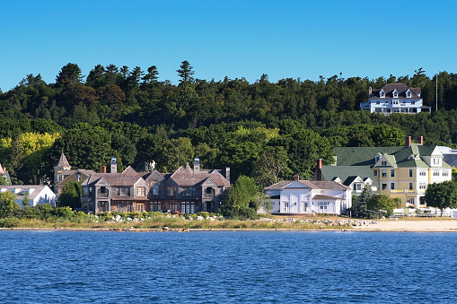 View of Antique houses and village at Mackinac Island in beautiful Summer from lake. Here located at Straits Between Michigan's Upper And Lower Peninsulas, Michigan,USA