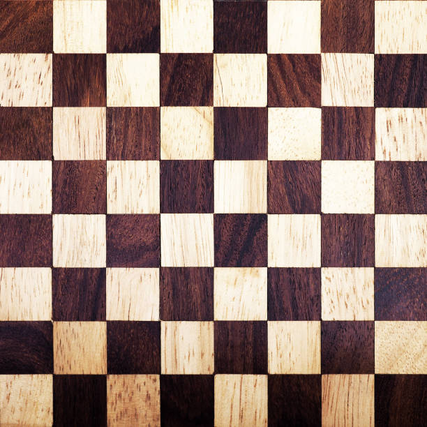 istock Wooden chess board background. Vintage chess board texture. White and black squares for popular game 944190176