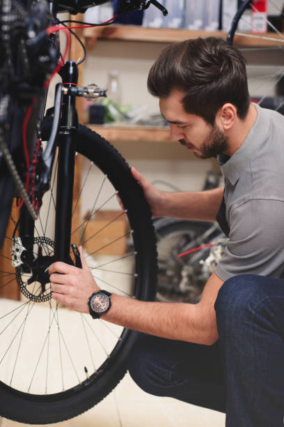 istock young male worker in apron fixing bicycle in workshop 944195734