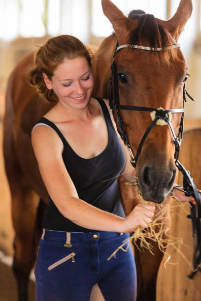 istock Woman hugging brown horse in stable 944199088